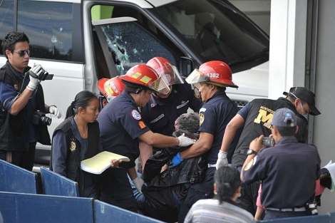 Bomberos retiran el cuerpo sin vida de Facundo Cabral del vehculo atentado. | AFP