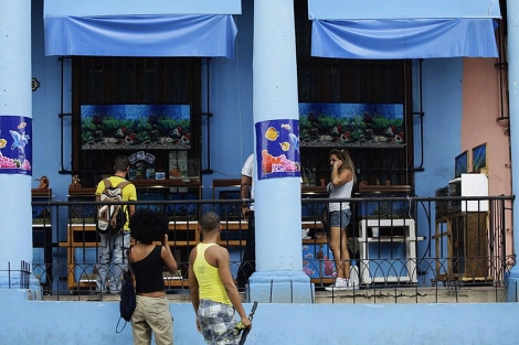 Dos personas miran la entrada a un acuario en La Habana. | AFP
