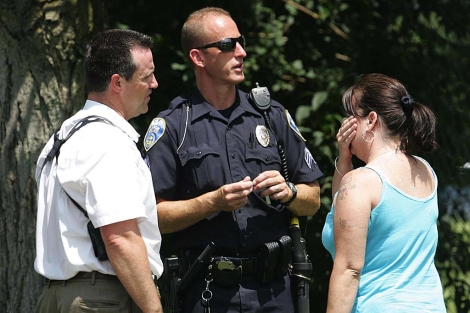 Miembros del Departamento de Polica de Akron hablan con una mujer. | AP