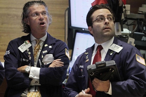 Dos corredores de bolsa observan el cierre de Wall Street. | AP