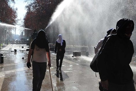 Tres estudiantes son reprimidos con chorros de agua durante una protesta. | AFP