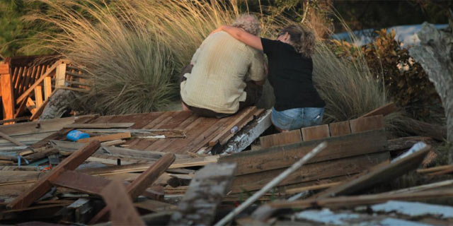 Dos personas se lamentan por las pérdidas causadas por 'Irene', en Carolina del Norte. | Afp