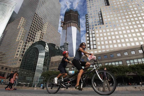 Una mujer y su hijo pasean en bicicleta por el 'World Financial Center' de Nueva York. | AFP