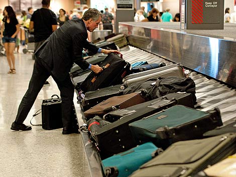 Un viajero recoge su maleta en el aeropuerto de Dulles. | Afp