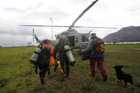 Unos buzos de dirigen a un helicptero para continuar con las labores de bsqueda. | AP
