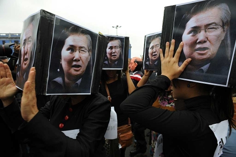 Activistas cargan imgenes compuestas de Alberto Fujimori y de su hija Keiko. | Efe