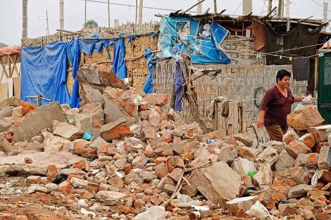 Una mujer mientras camina entre los escombros dos semanas despus del sismo de 2007. | Efe