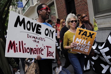 Un grupo de 'indignados' camina frente a casas de millionarios de Nueva York. | AFP