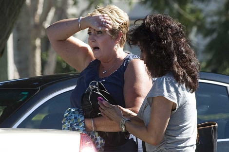 Una mujer reacciona a unos metros de la escena del crimen. | AP
