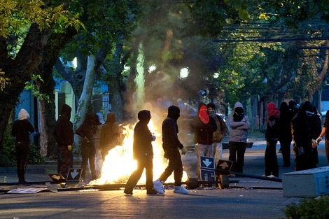 Encapuchados bloquean una va durante la jornada de protestas. | AFP