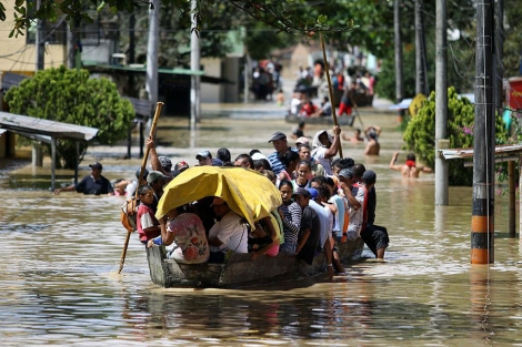 Varias personas se movilizan en canoas por calles inundadas de Bogot. | Efe