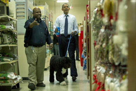 Un vendedor atiende a Obama con su mascota en una tienda de perros. | AP