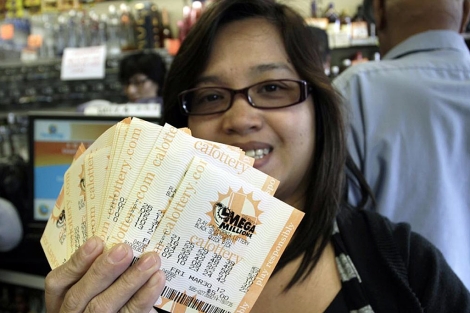 Una mujer muestra los boletos del Megamillions. | Reuters