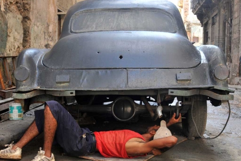 Un hombre repara un vehculo en La Habana.| El Mundo