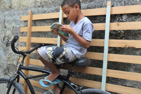 Un niño de la favela leyendo un cuento.| Ediciones Ambulantes