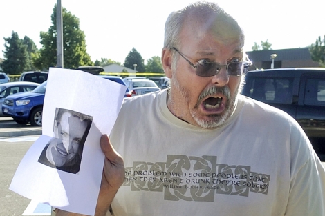 Tom Sullivan con la foto de su hijo Alex, fallecido en el tiroteo.| Reuters/ Evan Semin