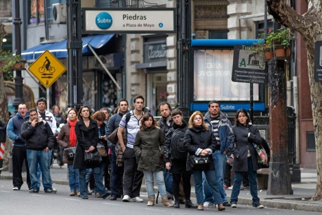 Gente esperando al autobs en una parada de Buenos Aires. | AFP