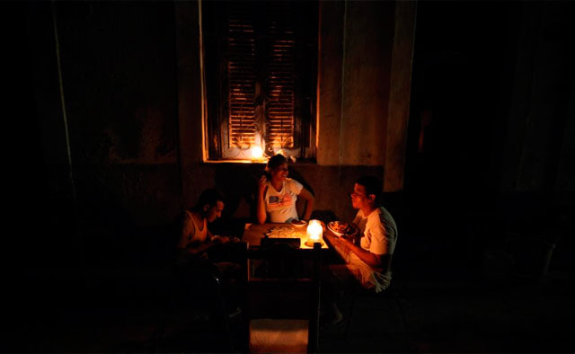 Vecinos cenan con velas en una calle de La Habana. | Efe