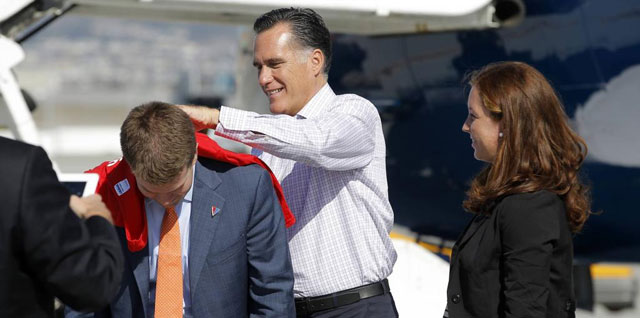 Romney firma un autgrafo en una camiseta en el aeropuerto de San Francisco. | Reuters