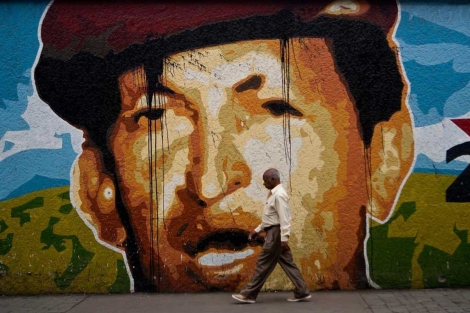 Un hombre pasea junto a un mural de Hugo Chvez.| Efe