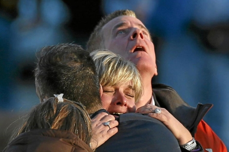 Familiares de las víctimas de la matanza se abrazan llorando.| Reuters
