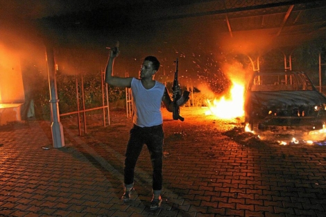 Un hombre armado celebra el incendio del consulado. | AFP