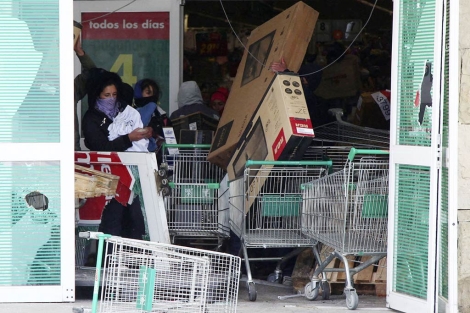 Grupo de encapuchados robando en un supermercado. | Reuters