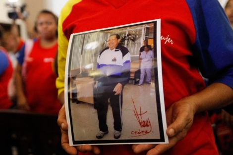 Una seguidora de Chvez sujeta una foto del mandatario. | Reuters