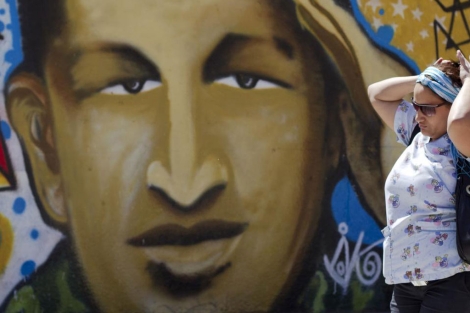 Una mujer pasea en Caracas frente a un mural de Chvez.| Reuters