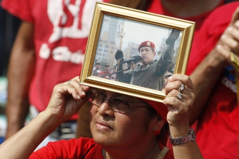 Una seguidora de Hugo Chávez sostiene una foto del presidente. | Reuters