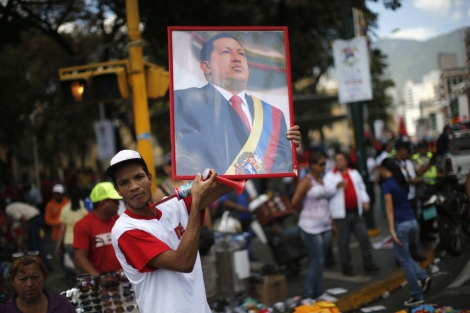 Un seguidor de Hugo Chvez muestra en Caracas una imagen del presidente. | Reuters