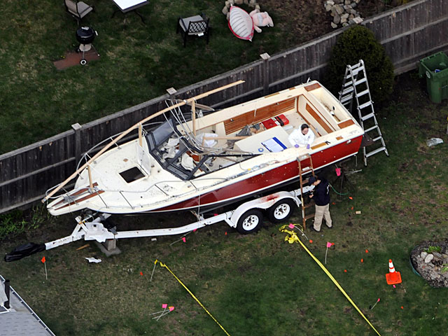 Dos policas toman huellas del barco (an con restos de sangre) donde se escondi Tsarnaev. | Afp