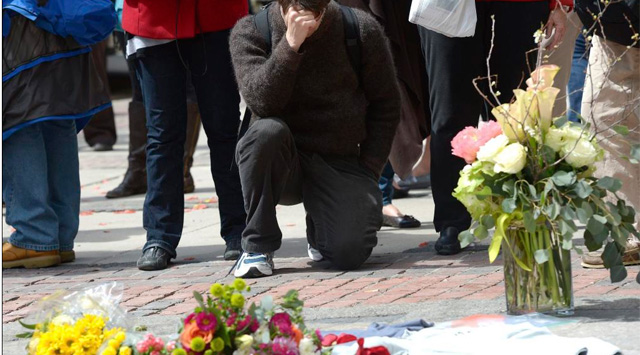 Un hombre se arrodilla en la calle en la que se registr la primera explosin en Boston.| Efe