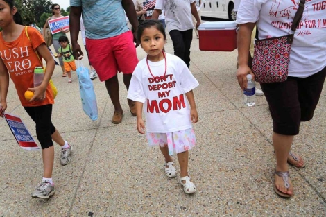 Una nia con una camiseta en la que se lee 'No deporten a mi madre'.| Reuters