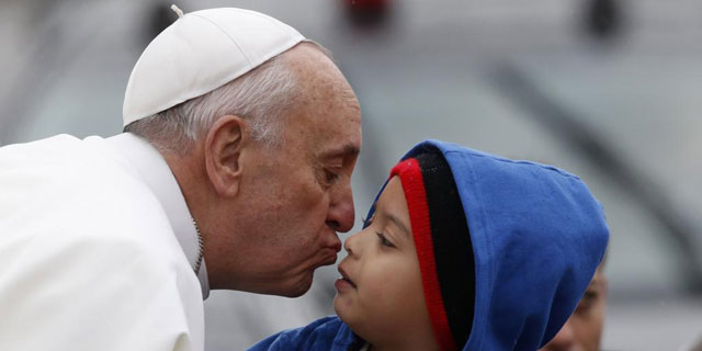 El Papa se dispone a besar a un nio en el santuario de la Virgen de Aparecida. | Reuters