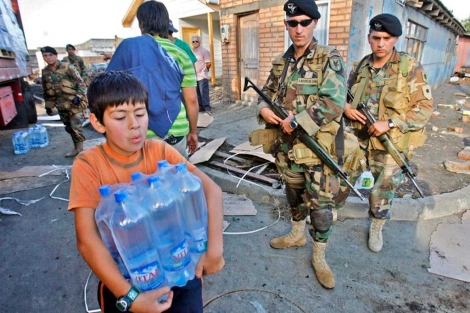 Dos soldados controlan el reparto de ayudas tras el terremoto de 2010. | Efe