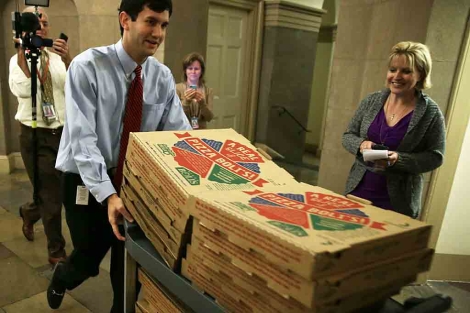 Un empleado trae pizzas en el Capitolio durante las negociaciones. | Afp
