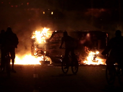 Uno de los vehculos incendiados ayer en los disturbios. | Afp