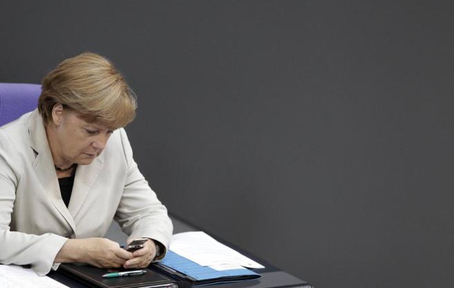 La canciller Angela Merkel manda SMS desde su mvil en el Parlamento...