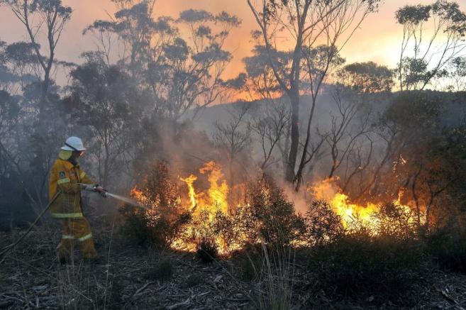 Un bombero trata de apagar el fuego en Nueva Gales del sur, al este de...