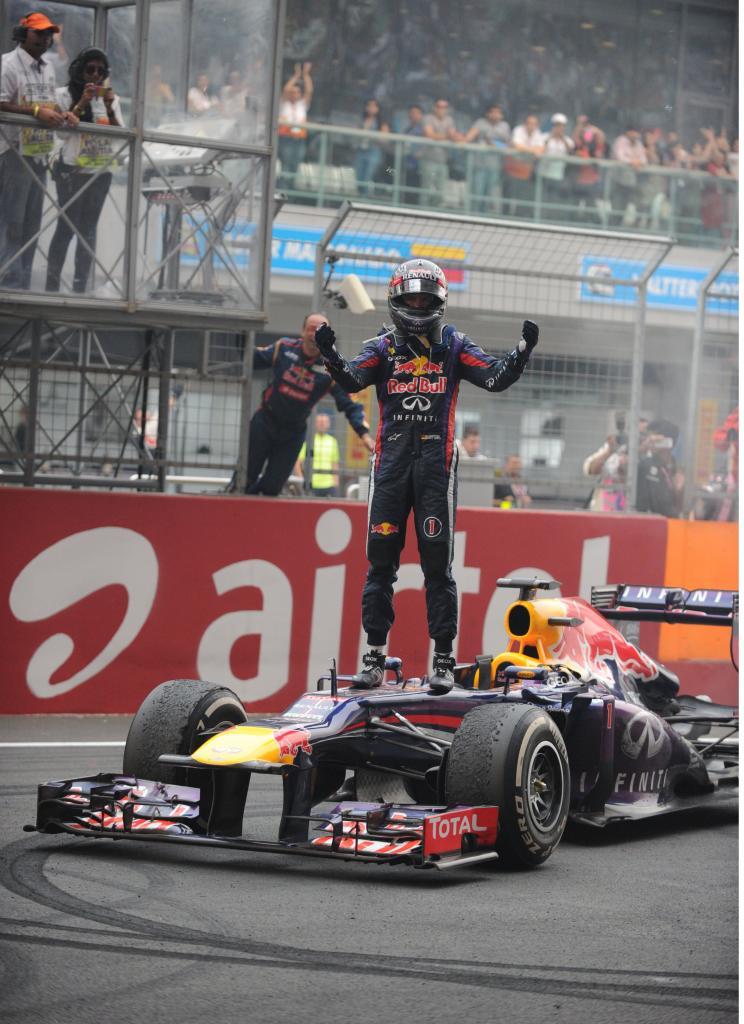 Vettel de pie sobre su coche celebrando el triunfo.