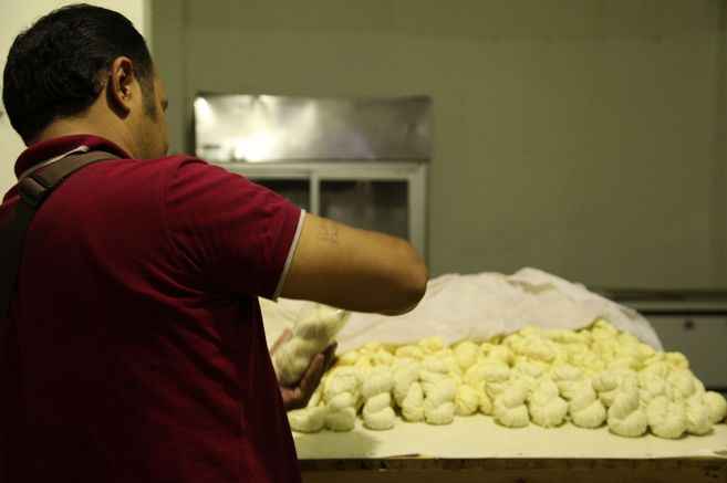 Un refugiado sirio prepara un queso trenzado en El Cairo