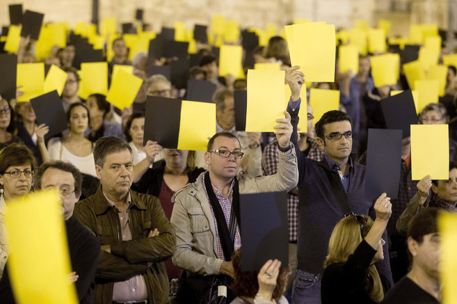 Manifestantes exhiben sus tarjetas frente al Palau de la Generalitat.