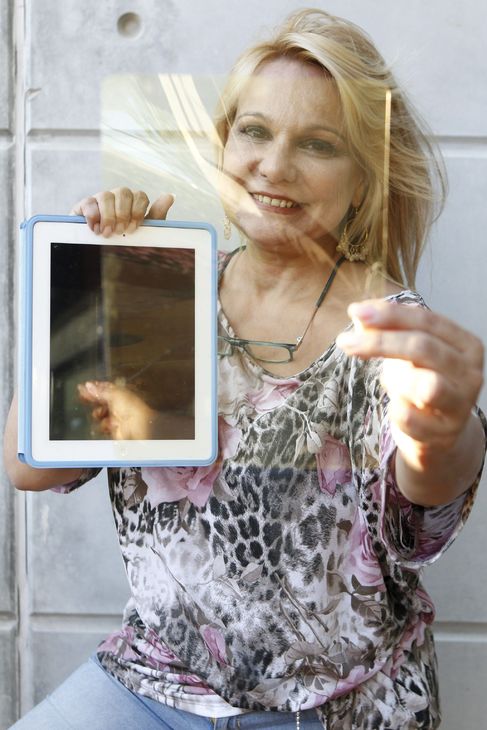 Una mujer sostiene un filtro amarillo ante una tableta iPad