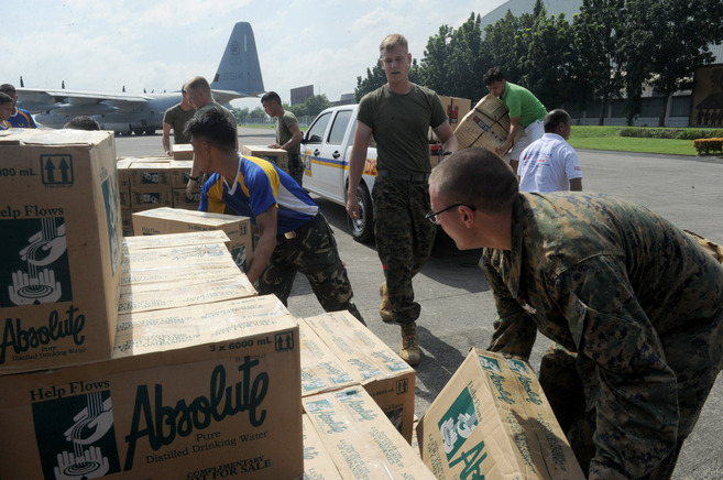 Soldados filipinos y norteamericanos se preparan para repartir ayuda a...