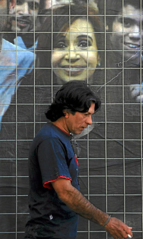 Un hombre camina delante de un cartel electoral en Buenos Aires.