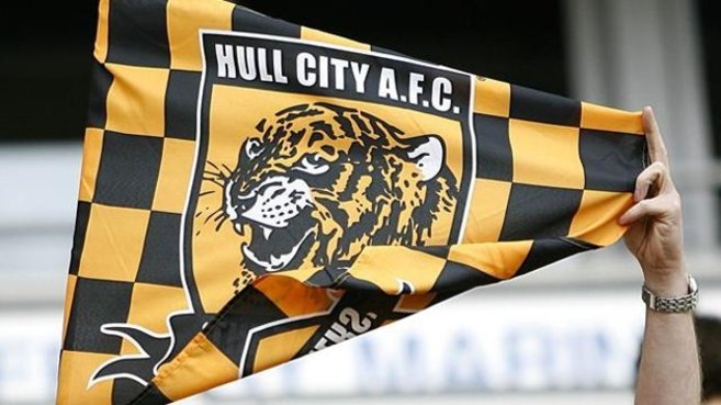 Un aficionado despliega una bandera con el escudo del Hull City.