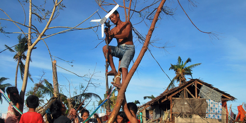 Una familia filipina intenta instalar un ventilador para generar...