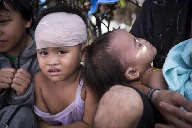 Dada, de 3 aos de edad, en el aeropuerto de Tacloban junto a su...