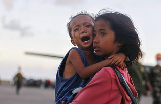 Una nia consuela a su hermano en Tacloban.